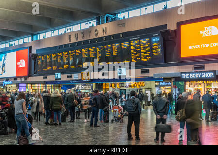 Passagiere in London Euston Station, London, England auf die bahnhofshalle Züge warten Stockfoto