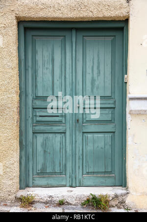 Holz- getragen und verblasste grüne Tür, geschlossenen Haus Eingang. Traditionelle Fassade, Altstadt Plaka, Athens Griechenland Stockfoto