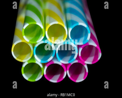 Colorly gestreifte Trinkhalme aus Kunststoff, schwarz u-Hintergrund Stockfoto