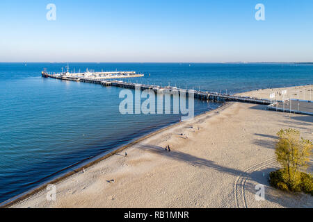 Hölzerne Seebrücke mit Hafen, Pirate touristische Schiff, Marina mit Yachten und Strand von Sopot Resort in der Nähe von Danzig in Polen im Abendlicht. Luftaufnahme Stockfoto