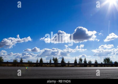 Stadt ​​Highway auf einem hellen, sonnigen Tag und Puffy Clouds Stockfoto