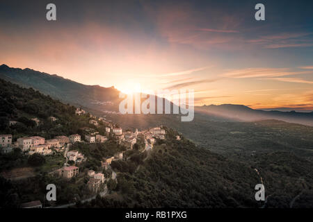 Sonnenuntergang hinter den Bergen über dem Dorf Belgodere in der Balagne Korsika Stockfoto