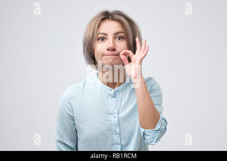 Kaukasische hübsche Frau zipping ihr Mund. Still-Konzept Stockfoto