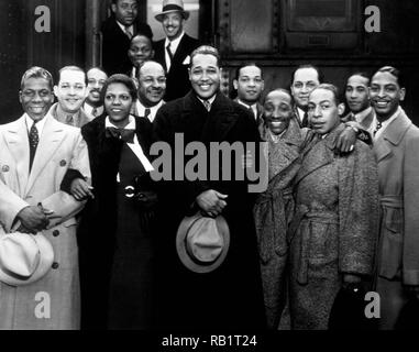 Gruppe Porträt der amerikanischen Jazzmusiker Duke Ellington und seine Band in Mäntel tragen vor einen Zug, Los Angeles, Kalifornien. Unter denen, die Bild sind: Harry Carney (ganz links), Sonny Greer (ganz rechts) und Ivie Anderson nex an den Herzog. 1934. Stockfoto