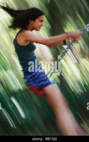 Glückliche junge Jugendmädchen genießen Sie einen Swing, Bewegungsunschärfe, USA Stockfoto