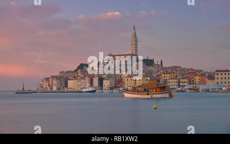 Blick auf die Stadt Rovinj in Kroatien. Rosa licht Sonnenuntergang mit langen Belichtungszeiten erzeugen Bewegung in Boote im Hafen Stockfoto