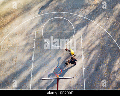 Vater und Sohn spielen Basketball im Park Luftaufnahme Stockfoto