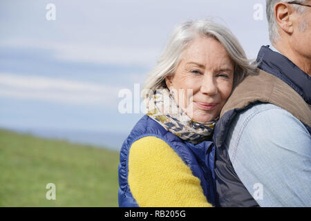 Portrait der älteren Frau ihren Ehemann im Freien umfassen Stockfoto