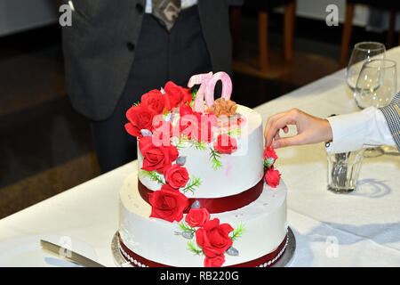 Familienfeier und Schneiden von Kuchen für den 70. Jahrestag Stockfoto