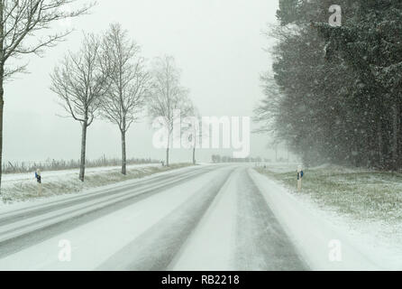 Schneesturm auf der Landstraße und gefährliche Straßenverhältnisse im Winter in der Schweiz Stockfoto