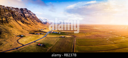 Dorf und malerische Straße in Island Luftbild Panorama bei Sonnenuntergang Stockfoto