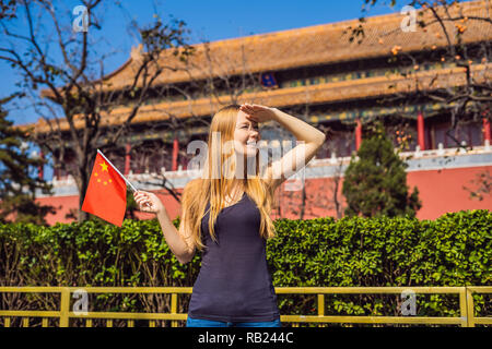 Genießen Sie Urlaub in China. Junge Frau mit nationalen chinesischen Flagge in der Verbotenen Stadt. Die Reise nach China. Kostenloses Visum Transit 72 Stunden, 144 Stunden in China Stockfoto