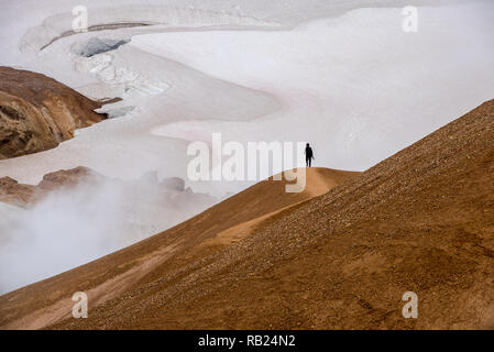 Wandern Person auf einem Hügel in den Rauch von der vulkanischen Landschaft Stockfoto