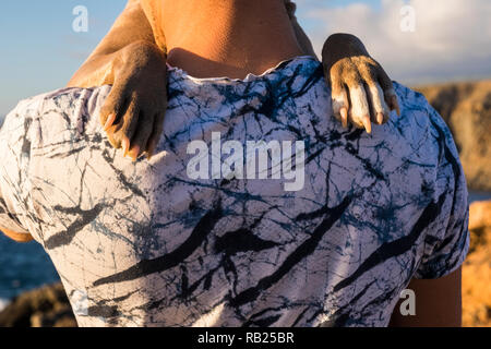 Ansicht der Rückseite des kaukasischen Mann seine besten Freunde Hund umarmt mit Liebe - Pfoten auf die Schulter wie Menschen - pet-Therapie und Freundschaft für immer Konzept-ou Stockfoto