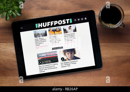 Die Website von HuffPost ist auf einem iPad Tablet gesehen, auf einer hölzernen Tisch zusammen mit einem Espresso und einem Haus Anlage (nur redaktionelle Nutzung). Stockfoto