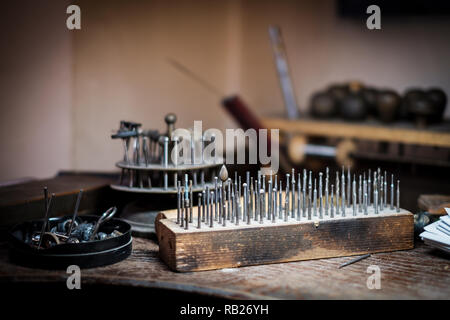 Der kleine Schleifmaschine pen Fräsen, Fräsen, Polieren, Bohren auf Holzbrett auf eine alte Werkbank in einem authentischen Schmuck workshop Stockfoto