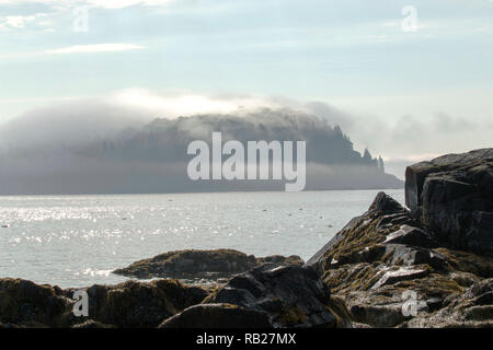 Ein Blick von der Bar Harbor Ufer eines der PORCUPINE Inseln im Nebel am frühen Morgen an einem schönen sonnigen Tag in Maine abgedeckt Stockfoto