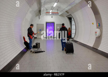 Ein strassenmusikant in der Londoner U-Bahn unterhält die Passagiere, die in einem der Tunnel an der Tottenham Court Road U-Bahnstation. Stockfoto