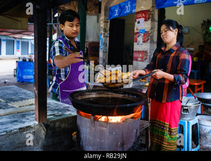 KYAING TONG, MYANMAR - ca. Dezember 2017: Kaufleute in der Nähe der Morgen Markt in Kyaing Tong Frühstück vorbereiten. Stockfoto