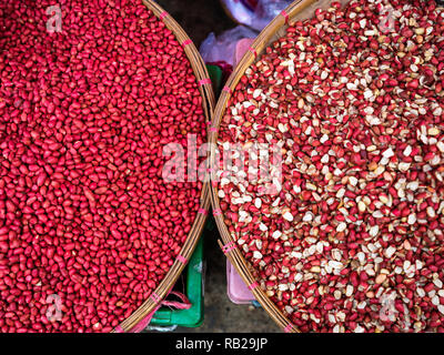 KYAING TONG, MYANMAR - ca. Dezember 2017: Körbe mit Erdnüssen an der Kyaing Tong Markt. Stockfoto