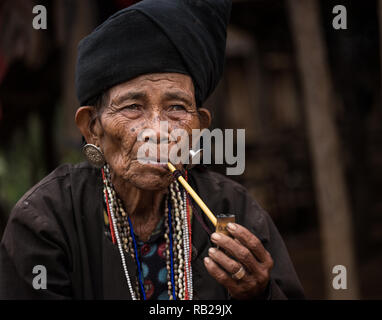 KYAING TONG, MYANMAR - ca. Dezember 2017: Porträt der älteren Frau der Wan Sai Akha Dorf in Kyaing Tong rauchen. Stockfoto