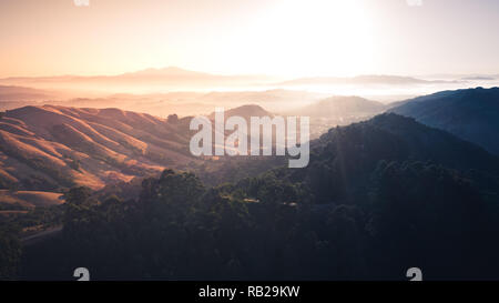 Sonnenaufgang über eine Berglandschaft. Berkeley Hills glühende mit Sonnenstrahlen mit Mount Diablo in der Ferne. Stockfoto