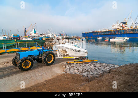 Traktor Entladen ein Boot auf dem Wasser für Touristen, Hafen Walvis Bay, Namibia Stockfoto