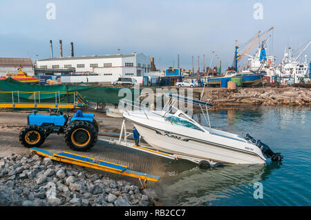 Traktor Entladen ein Boot auf dem Wasser für Touristen, Hafen Walvis Bay, Namibia Stockfoto