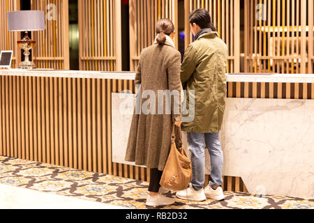 Asiatische paar Kontrolle im Hotel an der Rezeption. Stockfoto