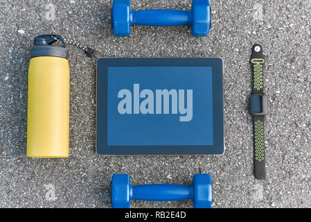 Smart sport Gadgets. Foto von dumpbells, Wasser und smart Watch bei Asphalt Hintergrund abgeschnitten. Sport motivation mobile Apps Stockfoto