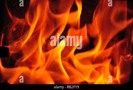 In der Nähe von brennenden Feuer mit gelben und roten Flammen in Gusseisen Ofen Stockfoto