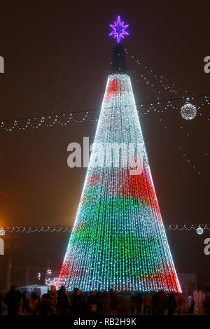 Minsk, Weißrussland - 30. Dezember 2018: Weihnachtsbaum, Illuminationen und Dekorationen vor dem Gebäude des Palastes der Republik in Oktyabrskaya Platz. Stockfoto