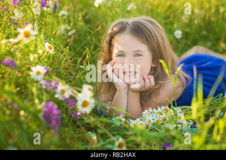 Mutter und Tochter auf ein Picknick in der Kamille Feld. Zwei schöne Blondinen in Kamille Feld auf dem Hintergrund eines Pferdes. Mutter und Tochter umarmen Stockfoto