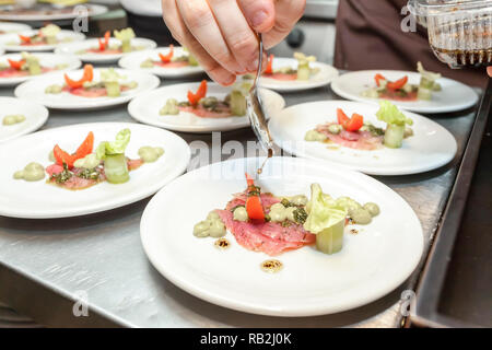 Der Küchenchef bereitet posh Antipasto mit Fischen Carpaccio, Wasabi und Salat Dressing Stockfoto