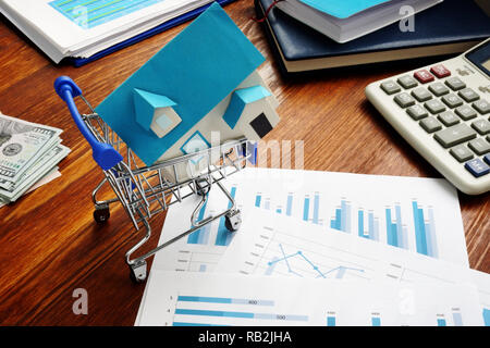 Real Estate Investment Trusts REITs. Warenkorb und Modell des Hauses. Stockfoto