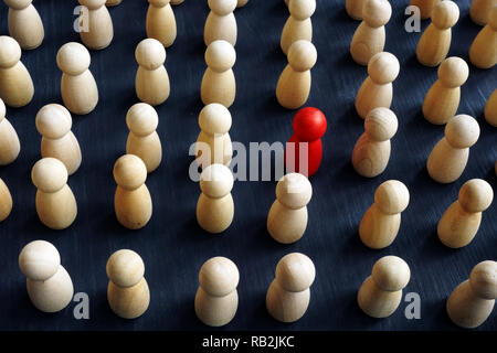 Einzigartig, individuell und anders denken. Masse von Holzfiguren und Rote. Stockfoto