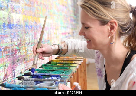 Ein kreatives Bewusstsein Frau Malerei mit Farbpalette Stockfoto