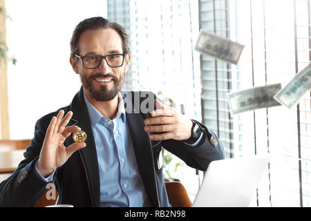 Business Lifestyle. Händler in Gläsern im Cafe sitzen mit Laptop wegwerfen von Banknoten cryptocurrency Münze lächelt glücklich auswählen Stockfoto