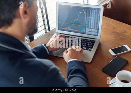 Business Lifestyle. Händler im Cafe mit Laptop Überwachung des Handels chart zurück Ansicht schließen Sitzen - bis Stockfoto