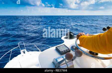 Hand von Captain am Lenkrad von Motorboot im blauen Ozean während der Fischerei. Erfolg angeln Konzept. Ocean Yacht Stockfoto