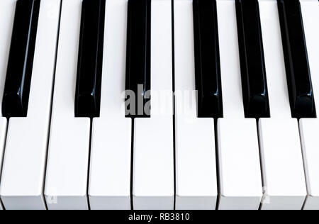 Blick von oben auf die Klaviertasten. In der Nähe der Tasten. In der Nähe der Vorderansicht. Klavier Keyboard mit selektiven Fokus. Blick diagonal. Klavier Keyboard Perspektive Stockfoto