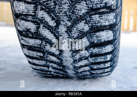Das Auto Reifen im Schnee hautnah. Auto Titel auf dem Schnee. Spuren der Auto im Schnee. Winterreifen. Reifen mit Schnee im Winter abgedeckt Stockfoto