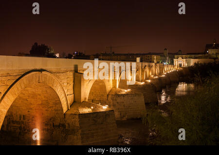 Spanien, Andalusien, Cordoba, Römische Brücke (Puente Romano) bei Nacht beleuchtet am Fluss Guadalquivir Stockfoto