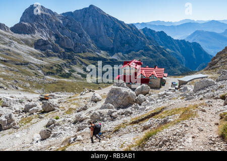 Touristische mit Wandern Rucksäcke in berg Wanderung auf Sommertag. Mann reisender Wandern in der herrlichen Bergwelt. Kletterer und Hütte in den Dolomiten Stockfoto