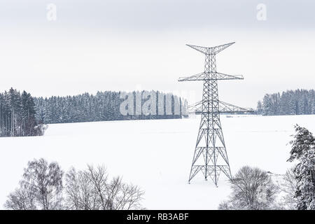 Bau von Hochspannungsmasten im Winter. Montiert Power Transmission Line unterstützt, bereit für die Installation. Stockfoto