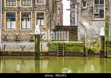Dordrecht, Niederlande, 6. Januar 2019: Treppenhaus zwischen zwei alten Backsteinhäuser im Herzen der historischen Altstadt, die auf das Wasser des Voorstra Stockfoto