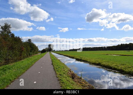 Country Road neben Wasser Kanal in Niederlande Stockfoto