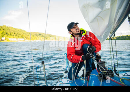 Yachtcharter sailor Seil ziehen. Mann bei der Arbeit auf Segelboot. Stockfoto