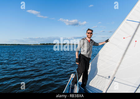 Schöner Mann ruht auf Yachtcharter in das offene Meer auf Kreuzfahrt. Stockfoto