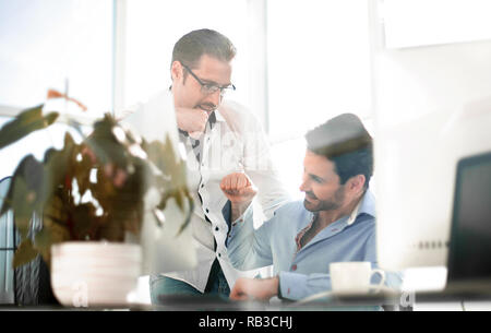 Geschäft Hintergrund. Zwei lächelnde männlichen Kollegen geben Faust Stößen Stockfoto